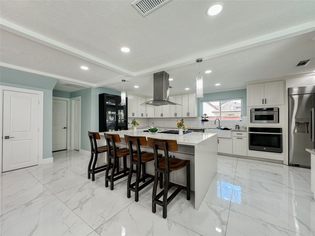 19310 Enchanted Oaks Drive Spring, TX 77388 - Photo 44 of 49 a kitchen with stainless steel appliances kitchen island granite countertop a table and chairs in it