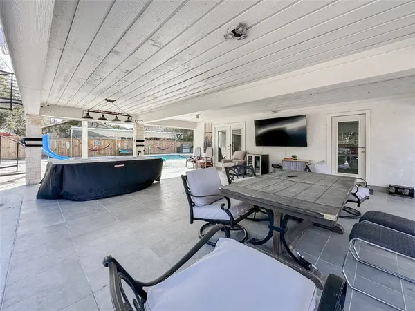 a living room with furniture a flat screen tv and kitchen view