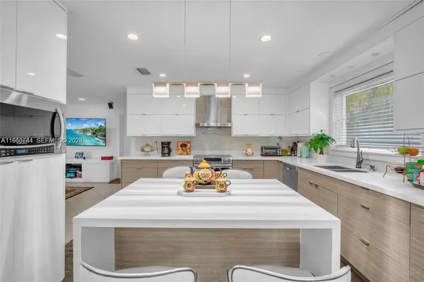 a kitchen with a sink a microwave a stove and refrigerator