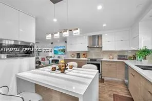 a kitchen with kitchen island granite countertop a sink a stove and cabinets