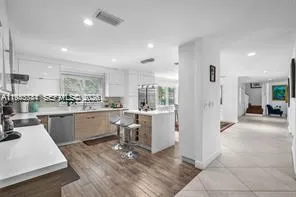a kitchen with white cabinets and refrigerator