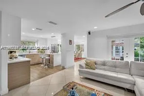 a living room with furniture and a view of kitchen