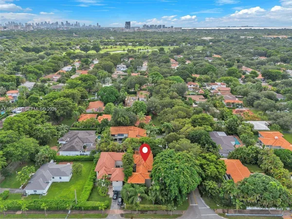 an aerial view of residential houses with outdoor space and trees