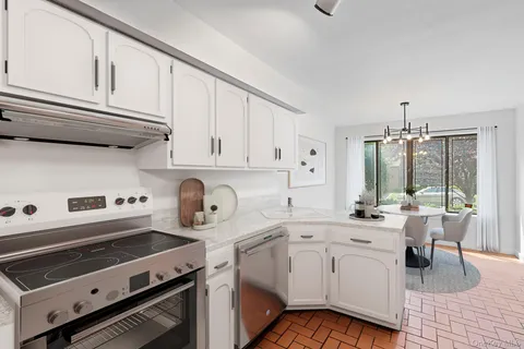 a view of kitchen with sink a stove and cabinets