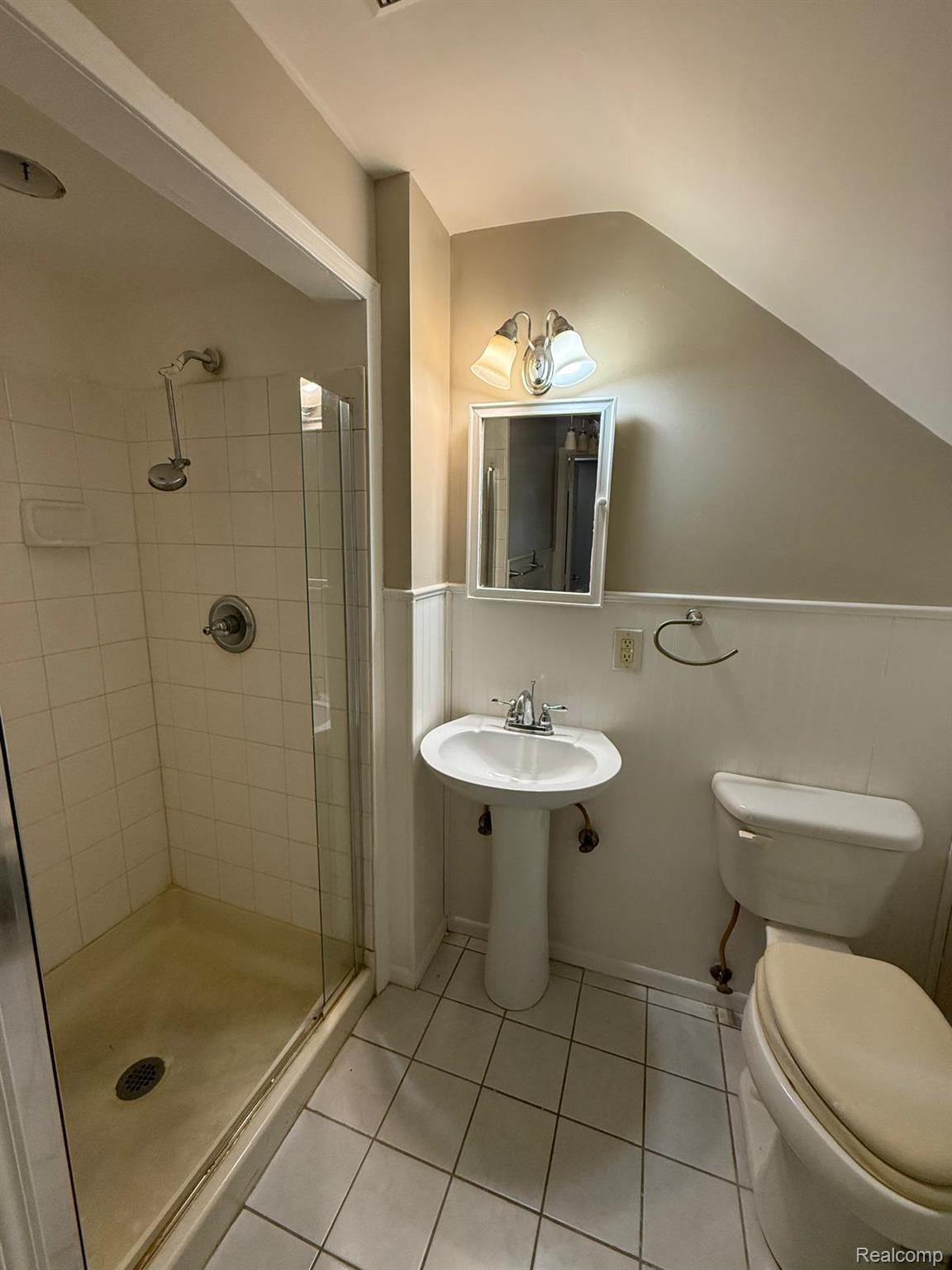 20231 Moross Road Detroit, MI 48224 - Photo 11 of 23 Full bathroom featuring a stall shower, light tile patterned floors, a wainscoted wall, and lofted ceiling