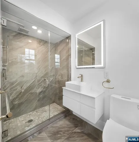 a bathroom with a sink mirror toilet and next to a window