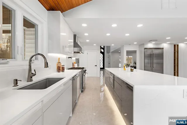 a large kitchen with stainless steel appliances kitchen island a sink a stove and a refrigerator