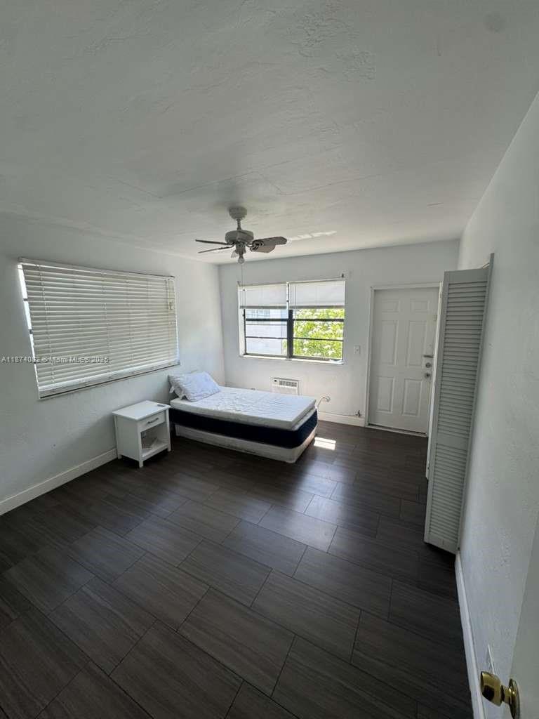 7320 Carlyle Avenue, Unit 4 Miami Beach, FL 33141 - Photo 8 of 8 a spacious bedroom with a bed and a window