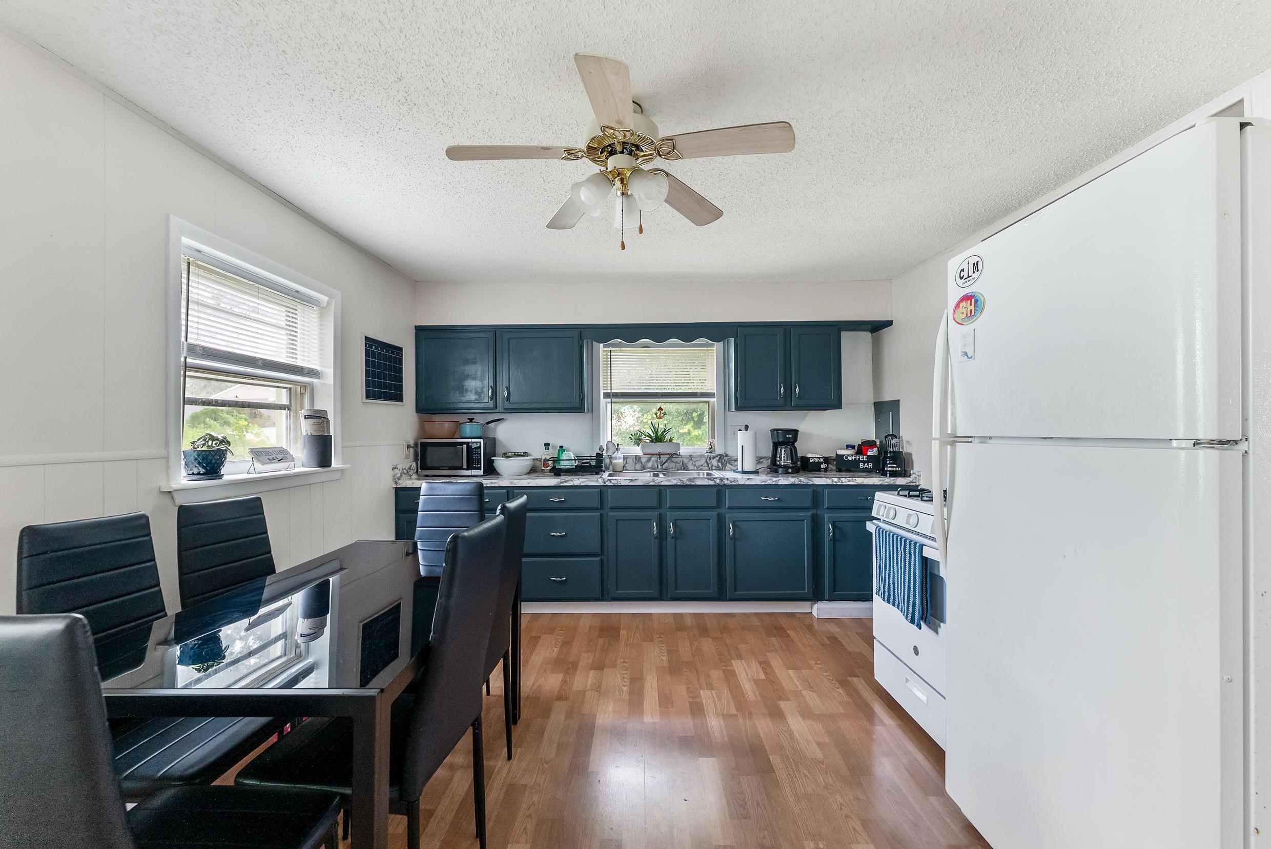 213 Langs Avenue Villas, NJ 08251 - Photo 4 of 20 a kitchen with a refrigerator a stove a sink dishwasher and a dining table with wooden floor