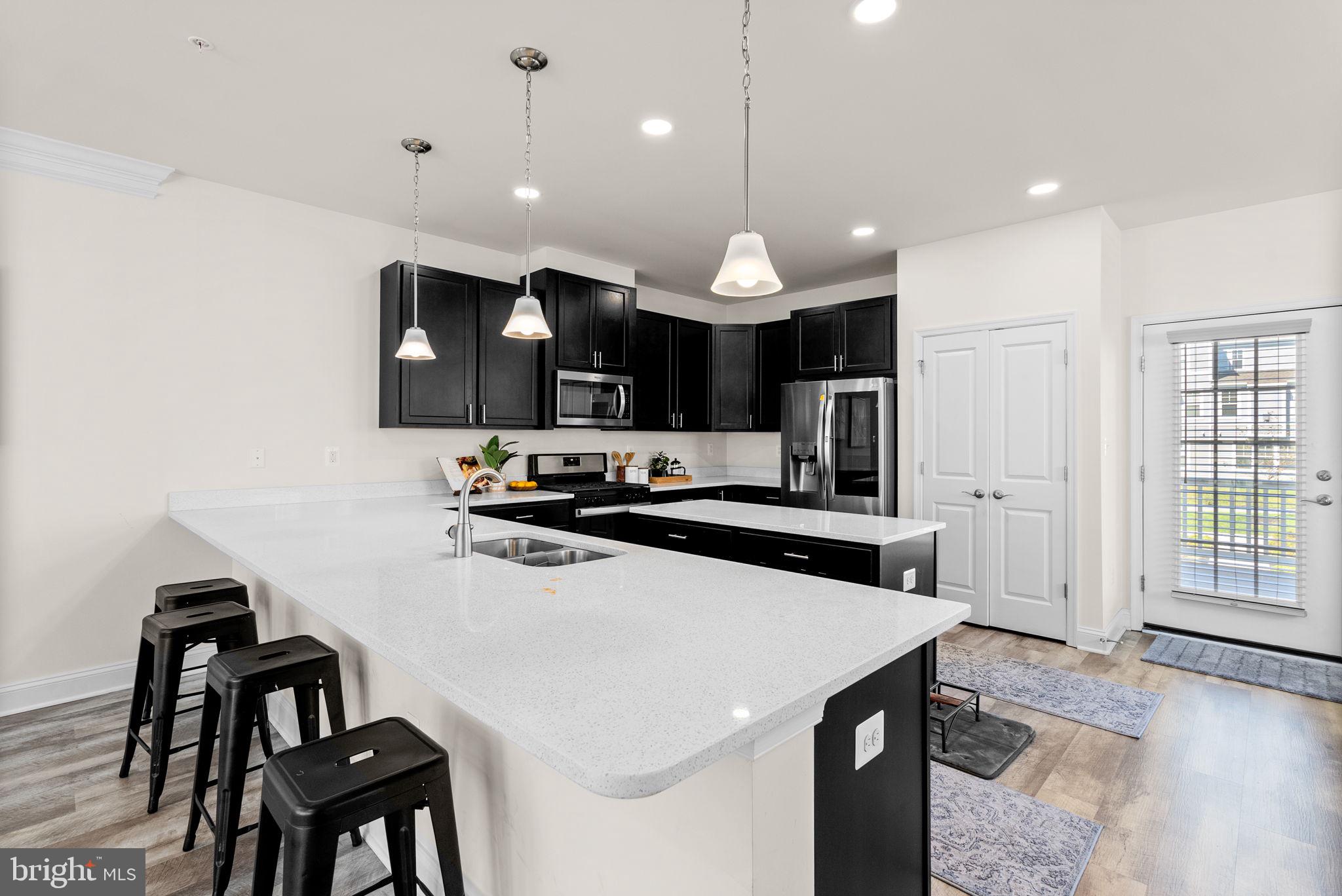 2 Hanover Road Reisterstown, MD 21136 - Photo 7 of 30 a kitchen with a sink a stove a refrigerator and chairs
