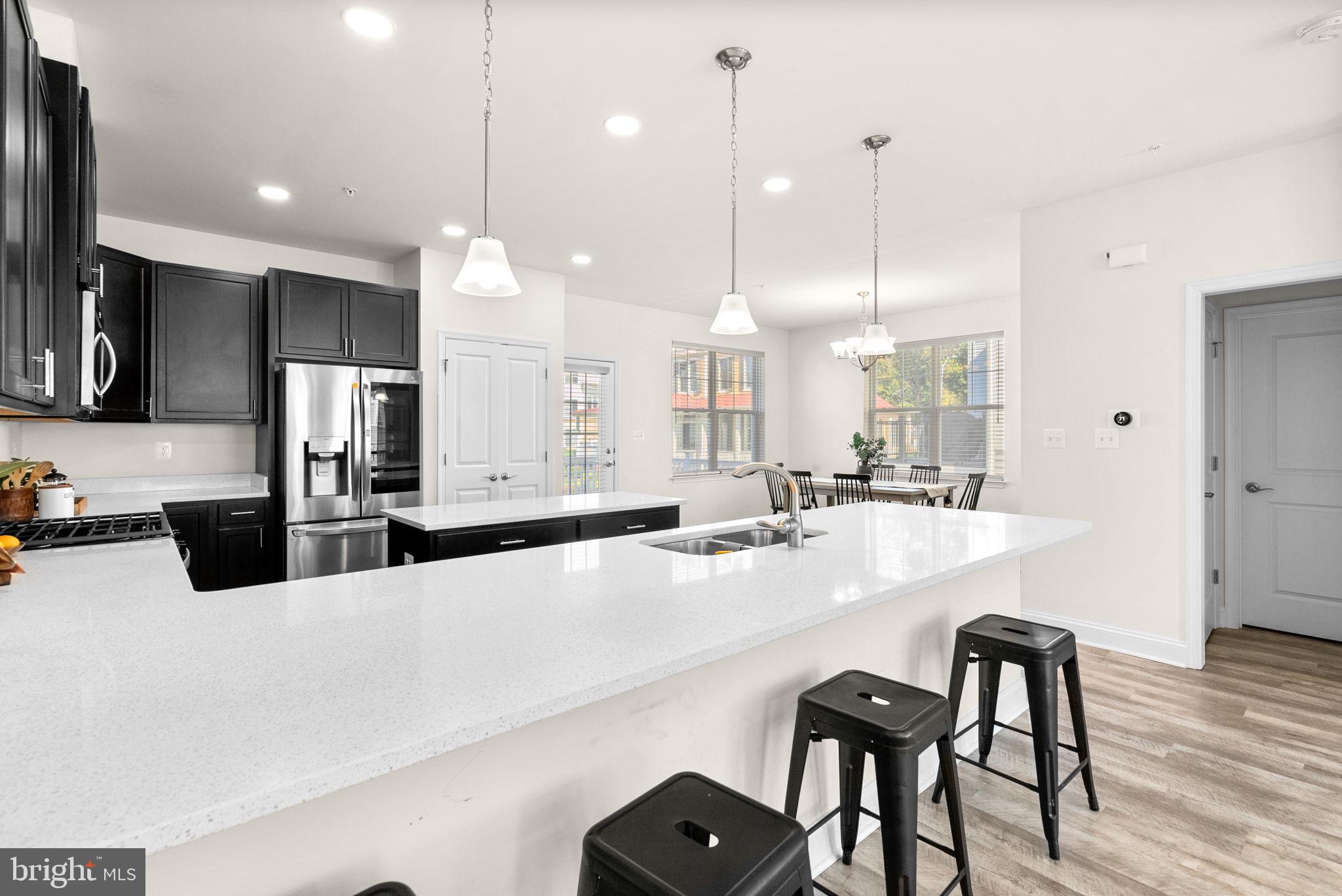 2 Hanover Road Reisterstown, MD 21136 - Photo 8 of 30 a large kitchen with kitchen island a dining table chairs and a wooden floor