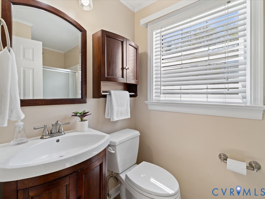 1455 Robindale Road Richmond, VA 23235 - Photo 20 of 29 a bathroom with a toilet a sink a mirror and a window