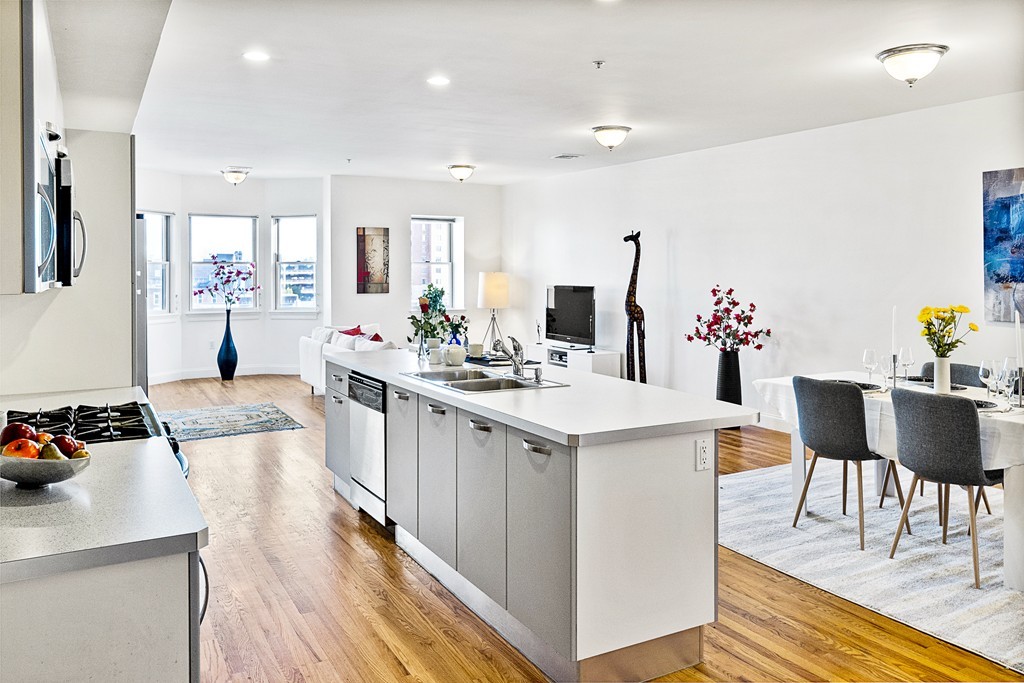 877 Harrison Avenue, Unit 7 Boston, MA 02118 - Photo 12 of 25 a large kitchen with kitchen island a dining table and chairs