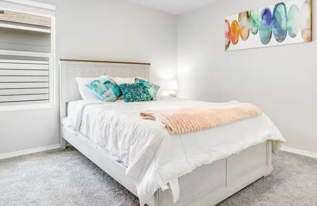 a bed sitting in a bedroom next to a window