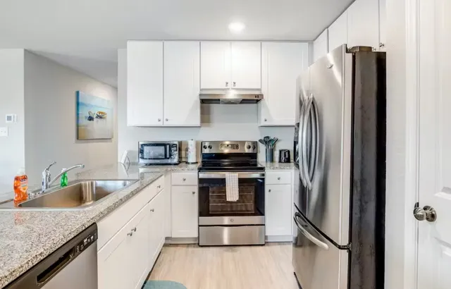 a kitchen with a refrigerator sink and stainless steel appliances