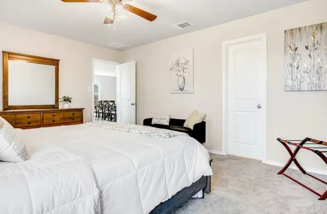 a bedroom with a large bed and a chandelier