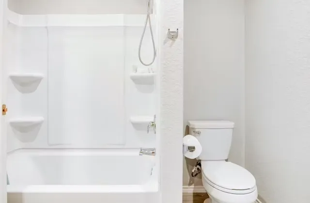 a white toilet sitting next to a bathroom sink