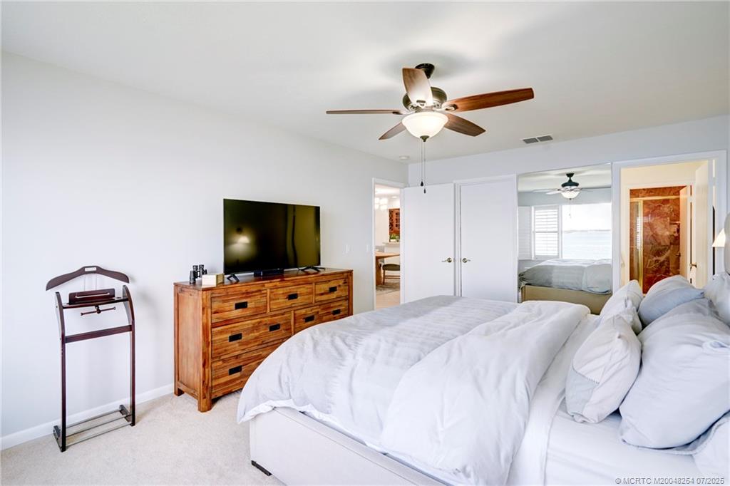 20 Northeast Plantation Road, Unit 307 Stuart, FL 34996 - Photo 35 of 52 a bedroom with a bed and a flat screen tv