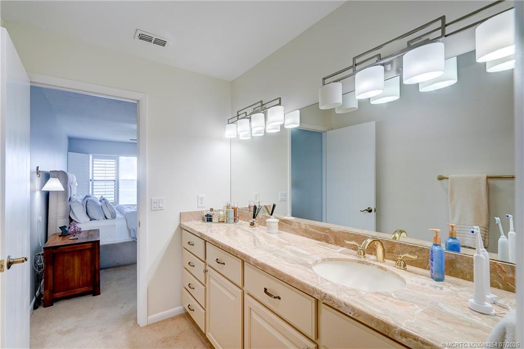 20 Northeast Plantation Road, Unit 307 Stuart, FL 34996 - Photo 39 of 52 a bathroom with a double vanity sink and a mirror