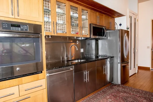 a kitchen with stainless steel appliances granite countertop a refrigerator a stove and a sink