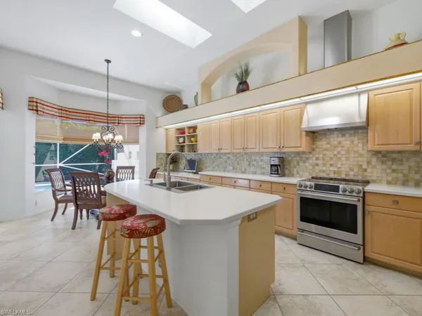 a kitchen with a stove a refrigerator and a dining table with wooden floor