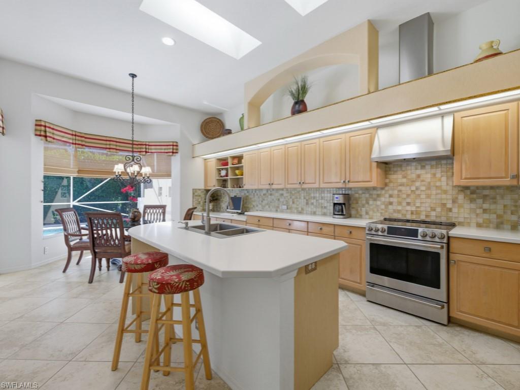 5835 Persimmon Way Naples, FL 34110 - Photo 1 of 50 a kitchen with a stove a refrigerator and a dining table with wooden floor