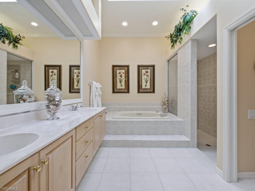 5835 Persimmon Way Naples, FL 34110 - Photo 12 of 50 a spacious bathroom with a tub sink and mirror