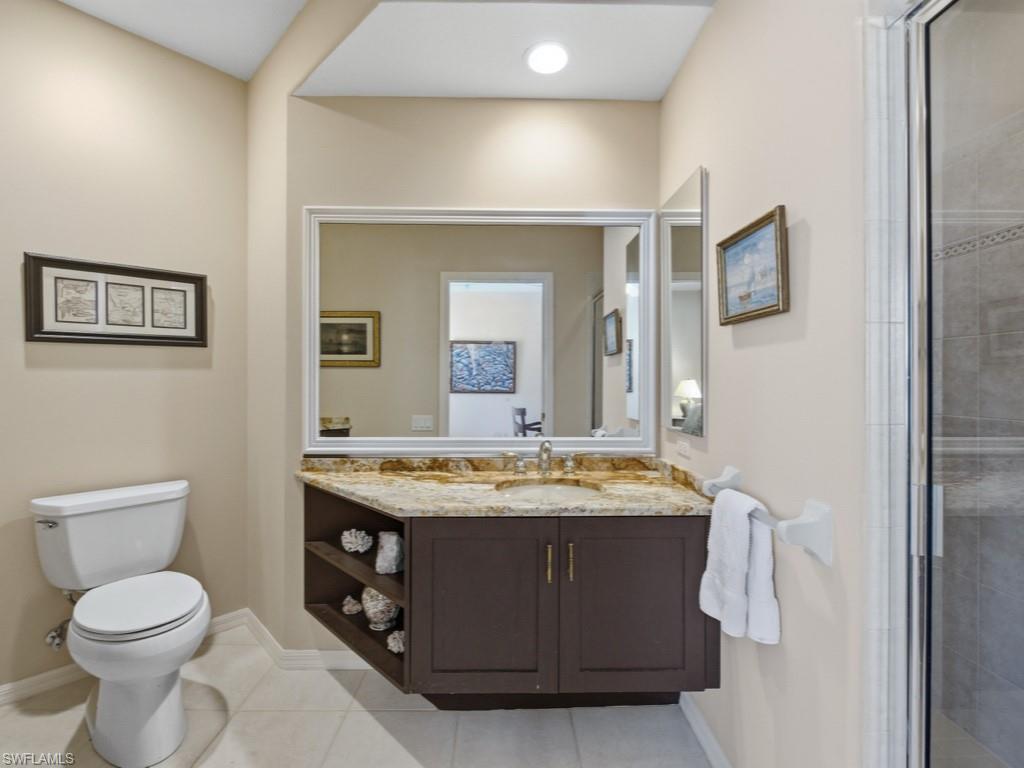 5835 Persimmon Way Naples, FL 34110 - Photo 17 of 50 a bathroom with a granite countertop sink a toilet and a mirror