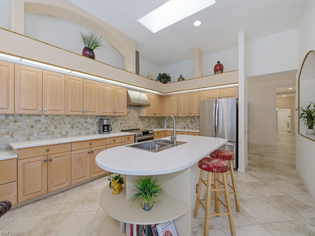 5835 Persimmon Way Naples, FL 34110 - Photo 2 of 50 a kitchen with stainless steel appliances granite countertop a sink a stove a dining table and chairs