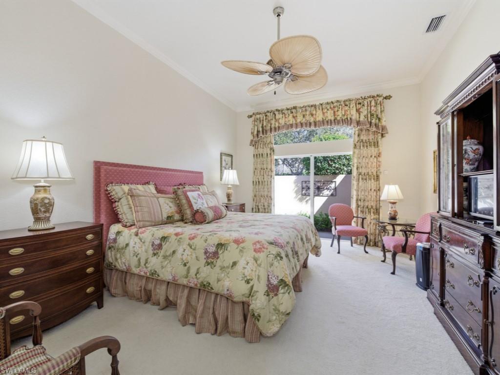 5835 Persimmon Way Naples, FL 34110 - Photo 10 of 50 a spacious bedroom with bed and a chandelier