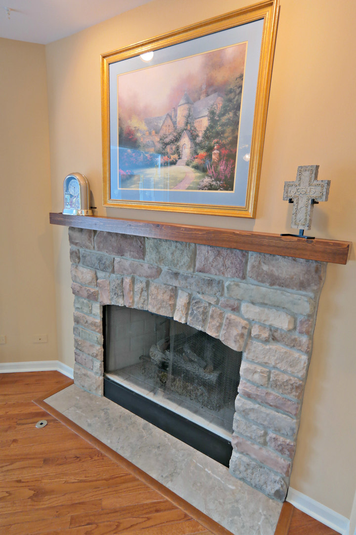 4115 Wilson Road Woodstock, IL 60098 - Photo 13 of 44 a living room with a fireplace and a painting on the wall
