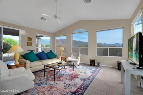a living room with furniture a large window and a flat screen tv