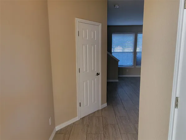 a view of a hallway with wooden floor and closet
