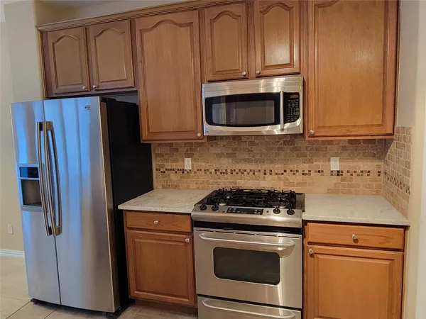 a kitchen with granite countertop cabinets and steel stainless steel appliances