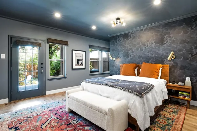 a bedroom with a bed lamp and a large window with outer view