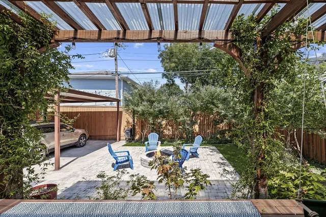 a view of the patio with couches and chairs under an umbrella