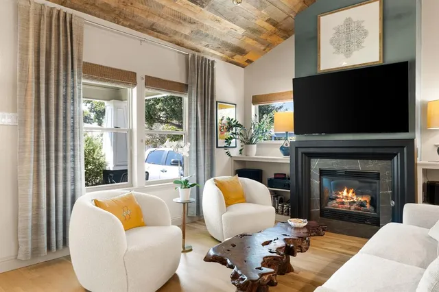 a living room with furniture a fireplace and a flat screen tv