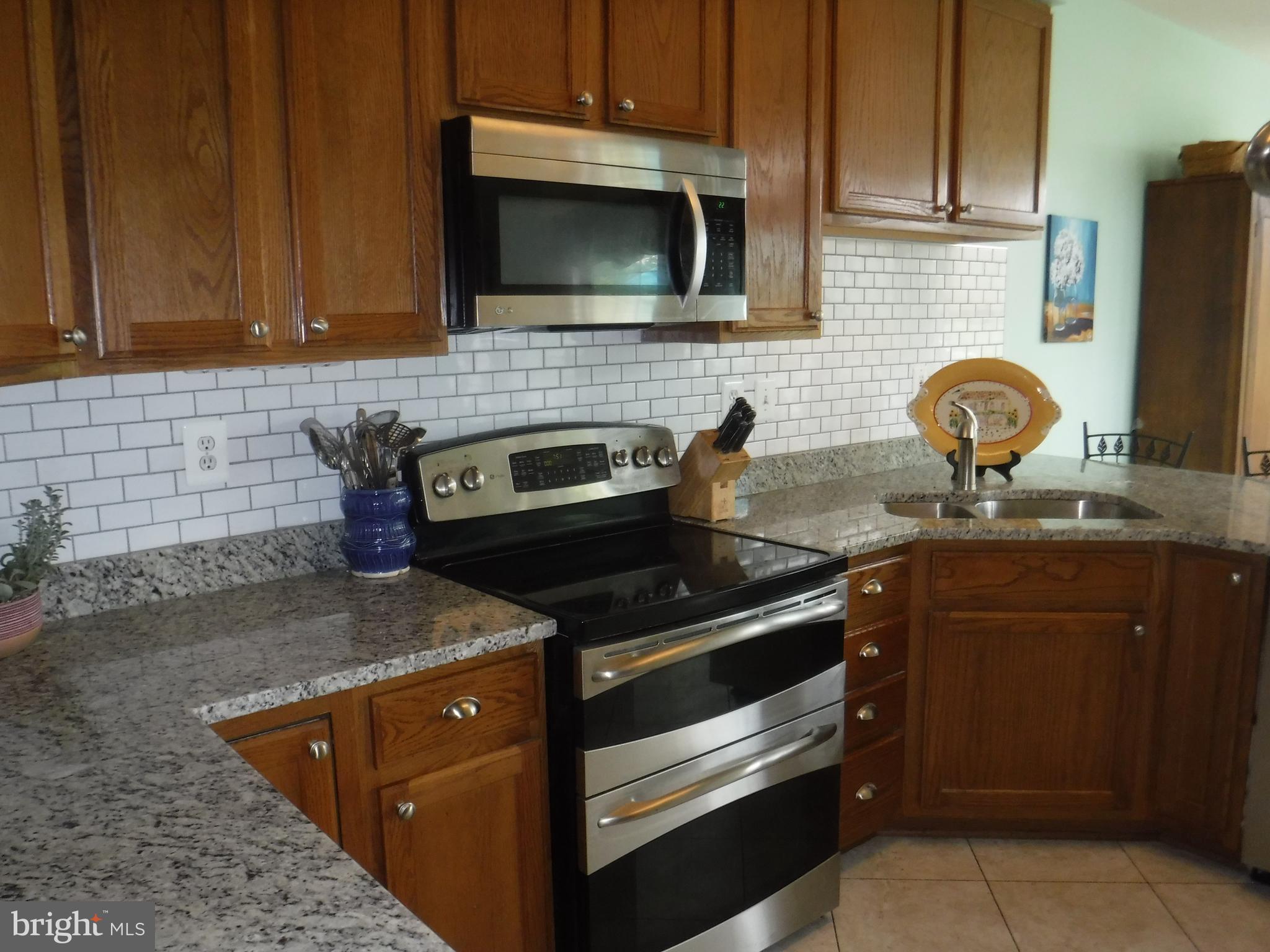 2444 Rippling Brook Road Frederick, MD 21701 - Photo 13 of 49 a kitchen with stainless steel appliances granite countertop a sink stove and microwave