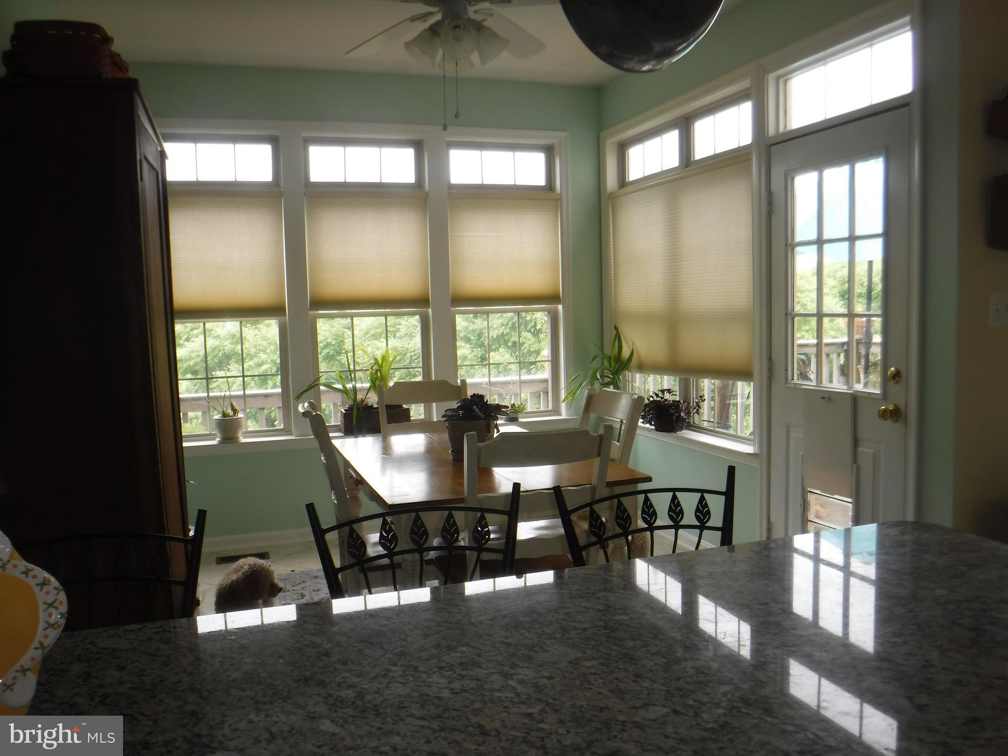 2444 Rippling Brook Road Frederick, MD 21701 - Photo 28 of 49 a dining room with wooden floor a glass table and chairs