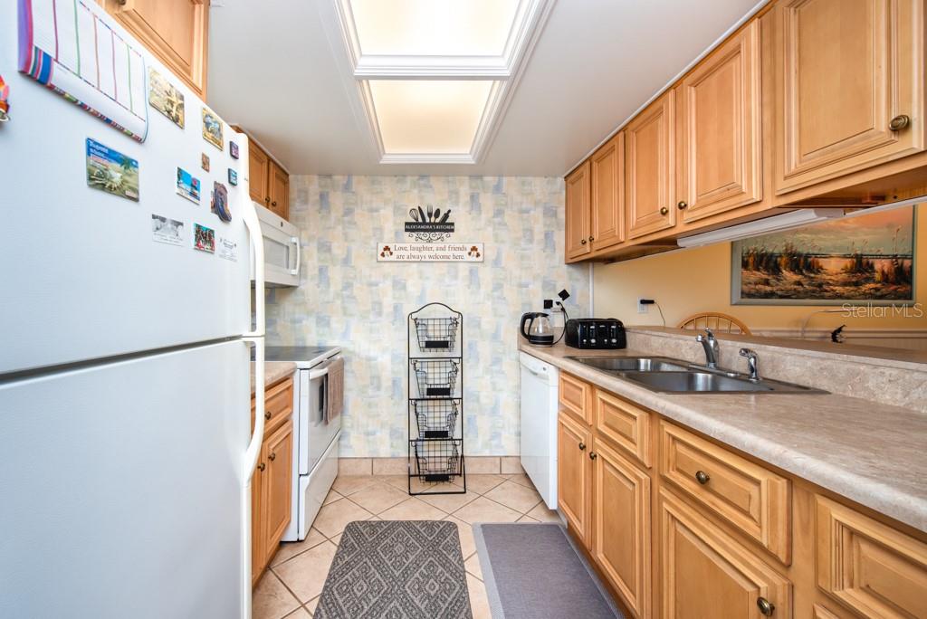 12760 Indian Rocks Road, Unit 601 Largo, FL 33774 - Photo 12 of 47 a kitchen with stainless steel appliances granite countertop a refrigerator a stove a sink and a refrigerator