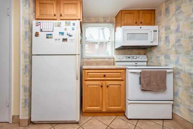 a white refrigerator freezer sitting in a kitchen
