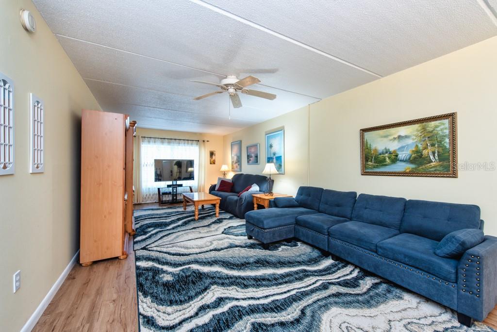 12760 Indian Rocks Road, Unit 601 Largo, FL 33774 - Photo 7 of 47 a living room with furniture a ceiling fan and a rug