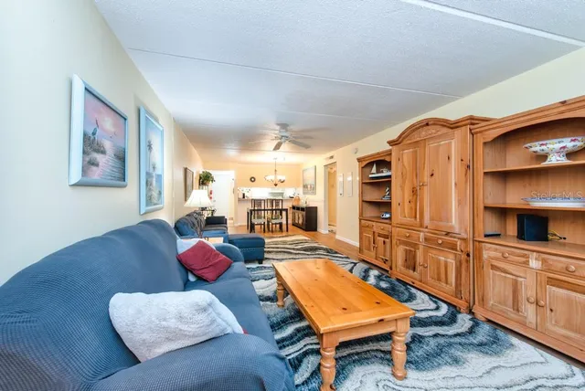 a living room with furniture a rug and kitchen view