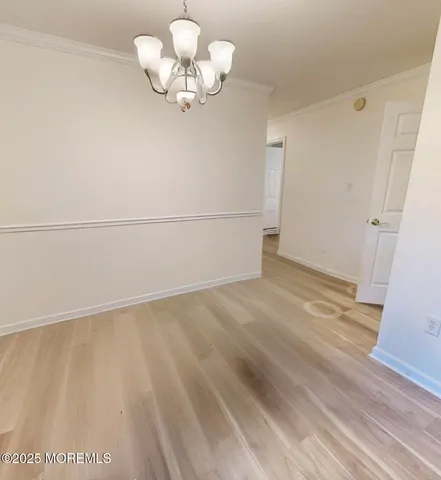 a view of a room with wooden floor and a ceiling fan