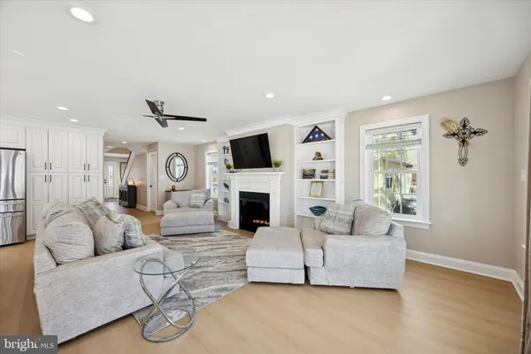 a room with a flat screen tv a ceiling fan and a window