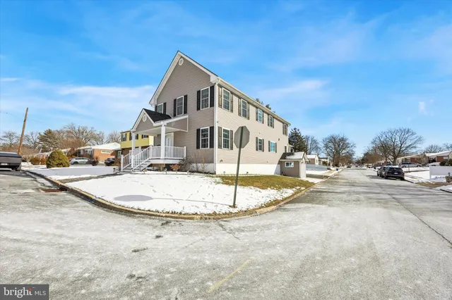 a view of a white house with a wooden fence