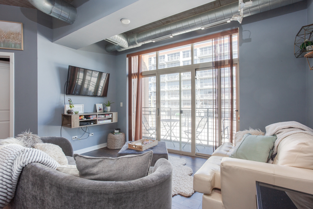 1228 West Monroe Street, Unit 407 Chicago, IL 60607 - Photo 7 of 15 a living room with furniture and a flat screen tv