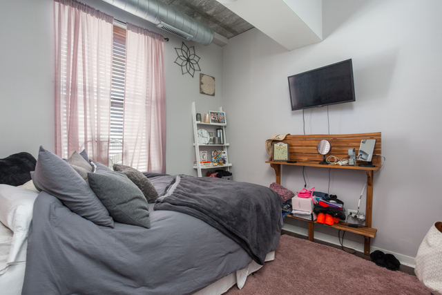 1228 West Monroe Street, Unit 407 Chicago, IL 60607 - Photo 9 of 15 a bedroom with furniture and a flat screen tv