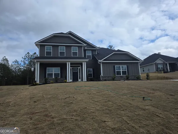 a front view of a house with yard and trees