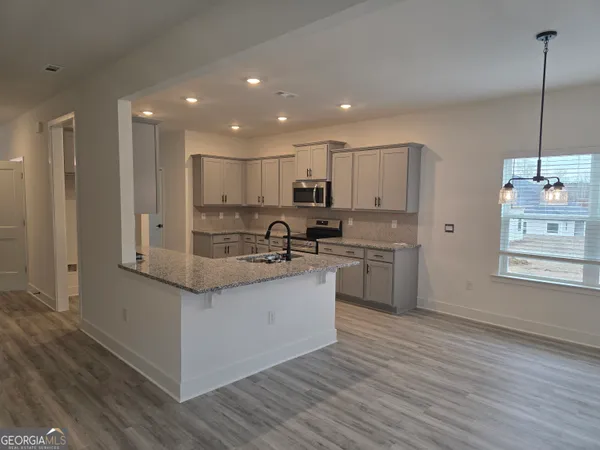 a kitchen with stainless steel appliances granite countertop a sink a stove and a refrigerator